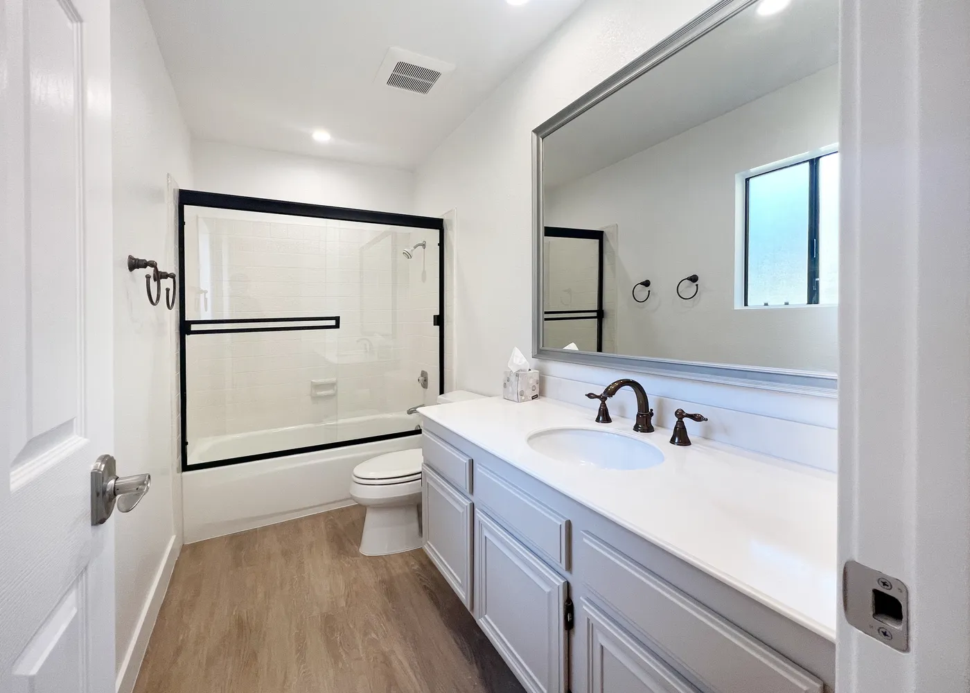 a bathroom with a double vanity sink toilet mirror and shower