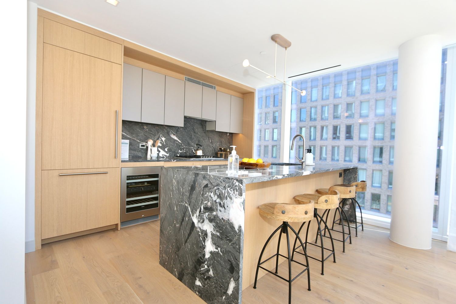 a kitchen with granite countertop a refrigerator oven a sink a dining table and chairs