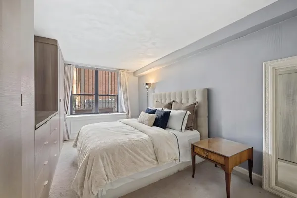 a bedroom with a bed a mirror and a window