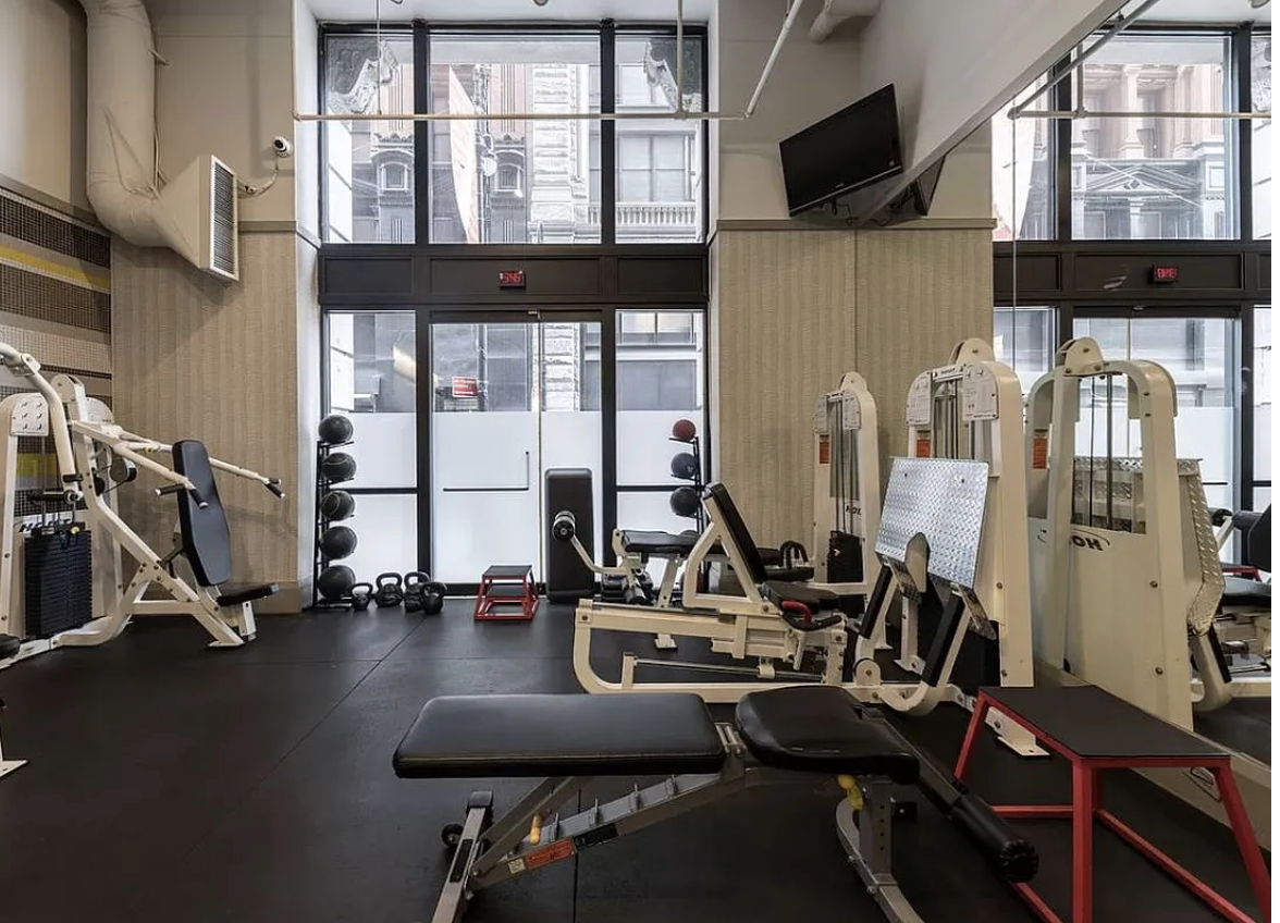 150 Nassau Street, Unit 11B Manhattan, NY 10038 - Photo 15 of 17 a room with gym equipment and a large window
