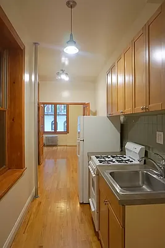 114 East 7th Street, Unit 1 Manhattan, NY 10009 - Photo 5 of 7 a kitchen that has a sink a stove and cabinets