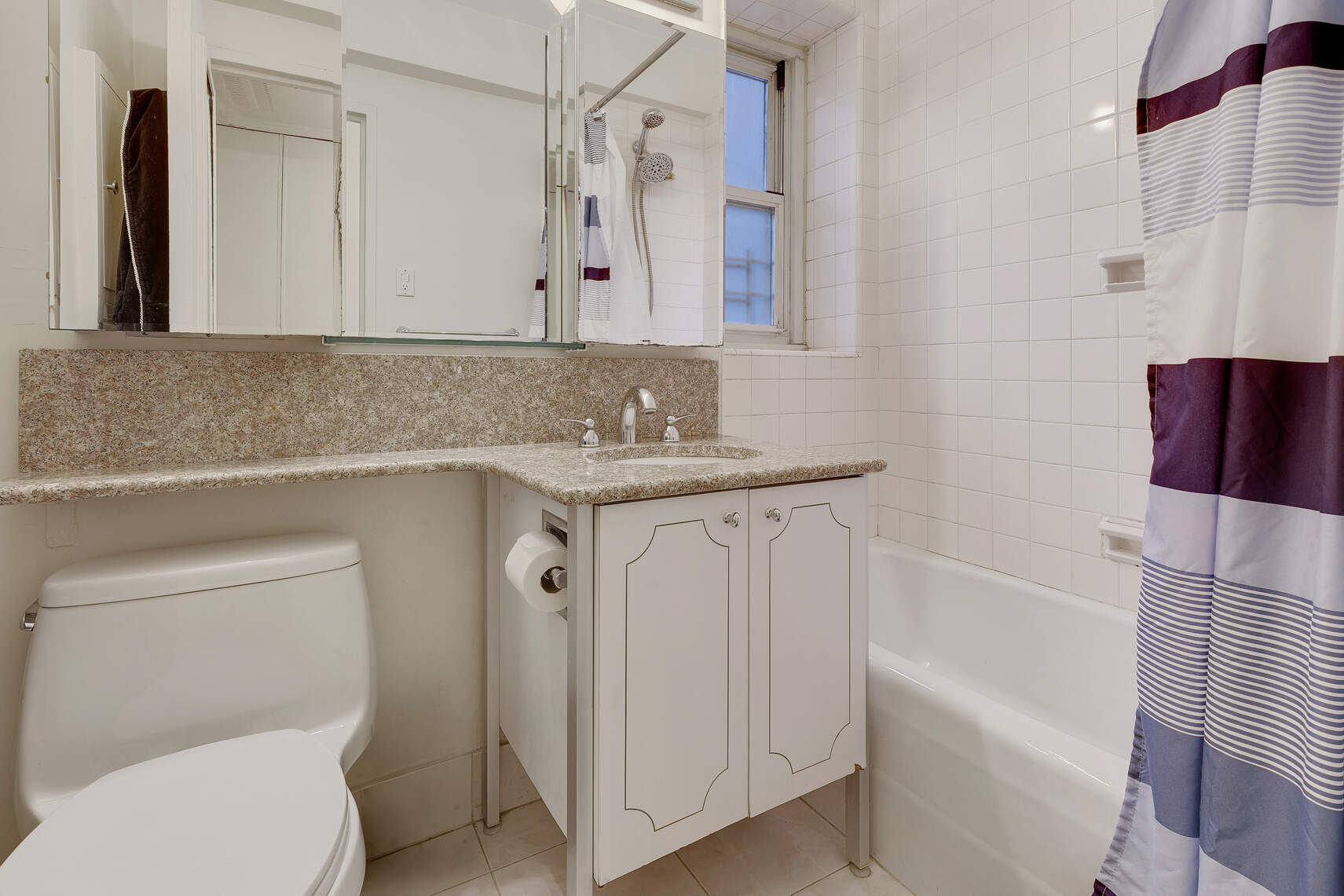 159 West 53rd Street, Unit 18A Manhattan, NY 10019 - Photo 4 of 8 a bathroom with a sink a toilet and a bathtub