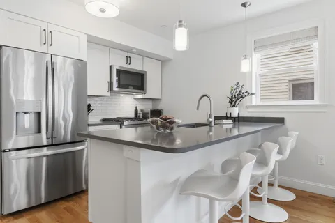 a kitchen with stainless steel appliances granite countertop a sink refrigerator and microwave