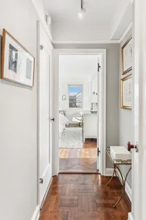 a view of a hallway with bathroom and wooden floor