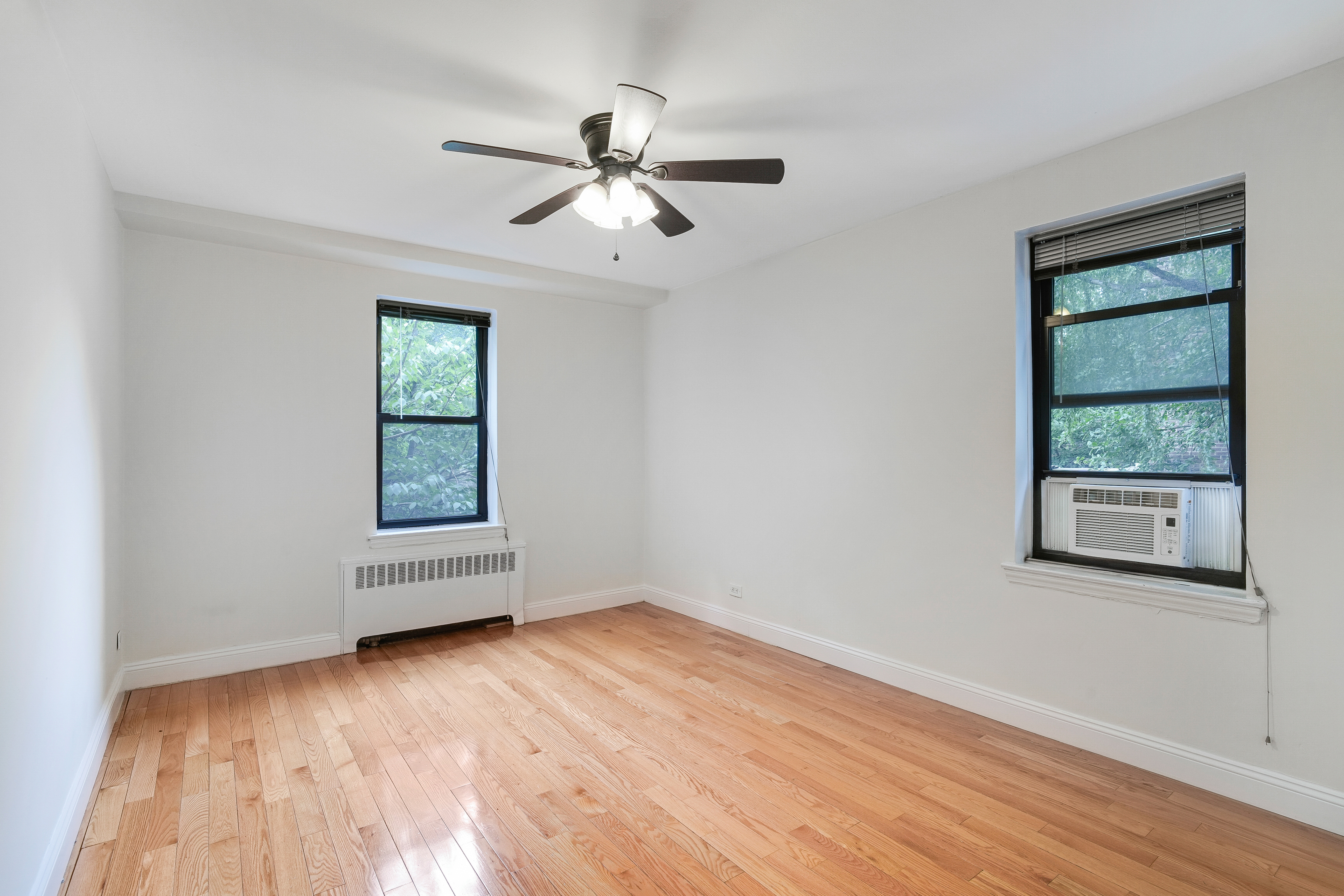 3840 Greystone Avenue, Unit 1K Bronx, NY 10463 - Photo 8 of 13 a view of empty room with wooden floor and fan