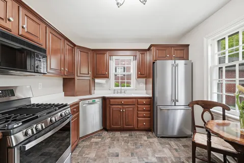 a kitchen with stainless steel appliances granite countertop sink stove top oven and cabinets