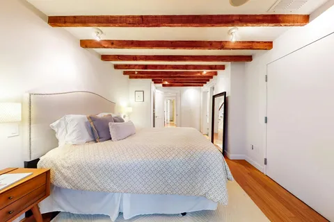 a bedroom with a bed and a potted plant