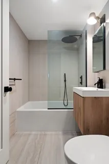 a bathroom with a sink a toilet a mirror and bathtub