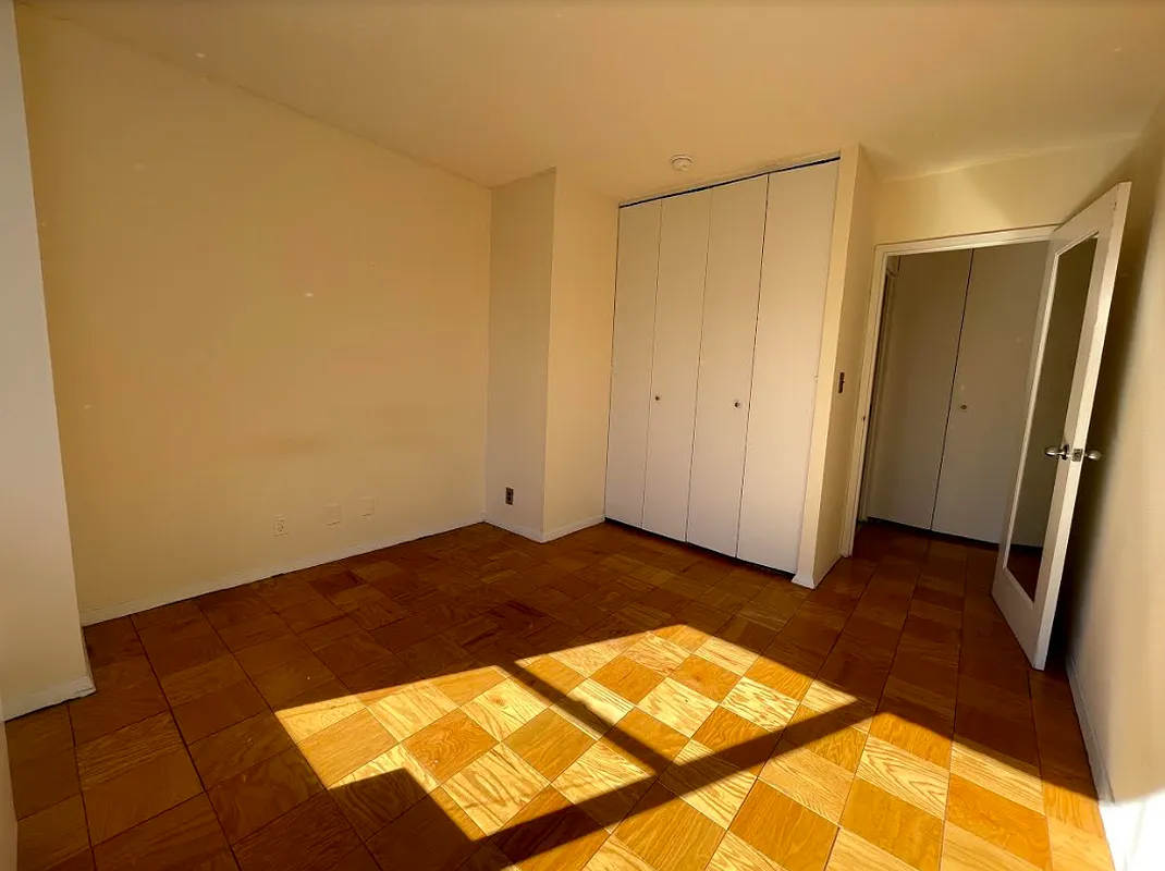 a view of a room with wooden floor and bathroom