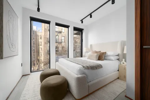 a bedroom with a bed and glass windows