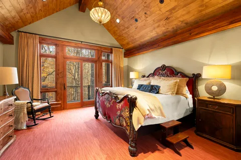 a large bedroom with a bed and a flat screen tv