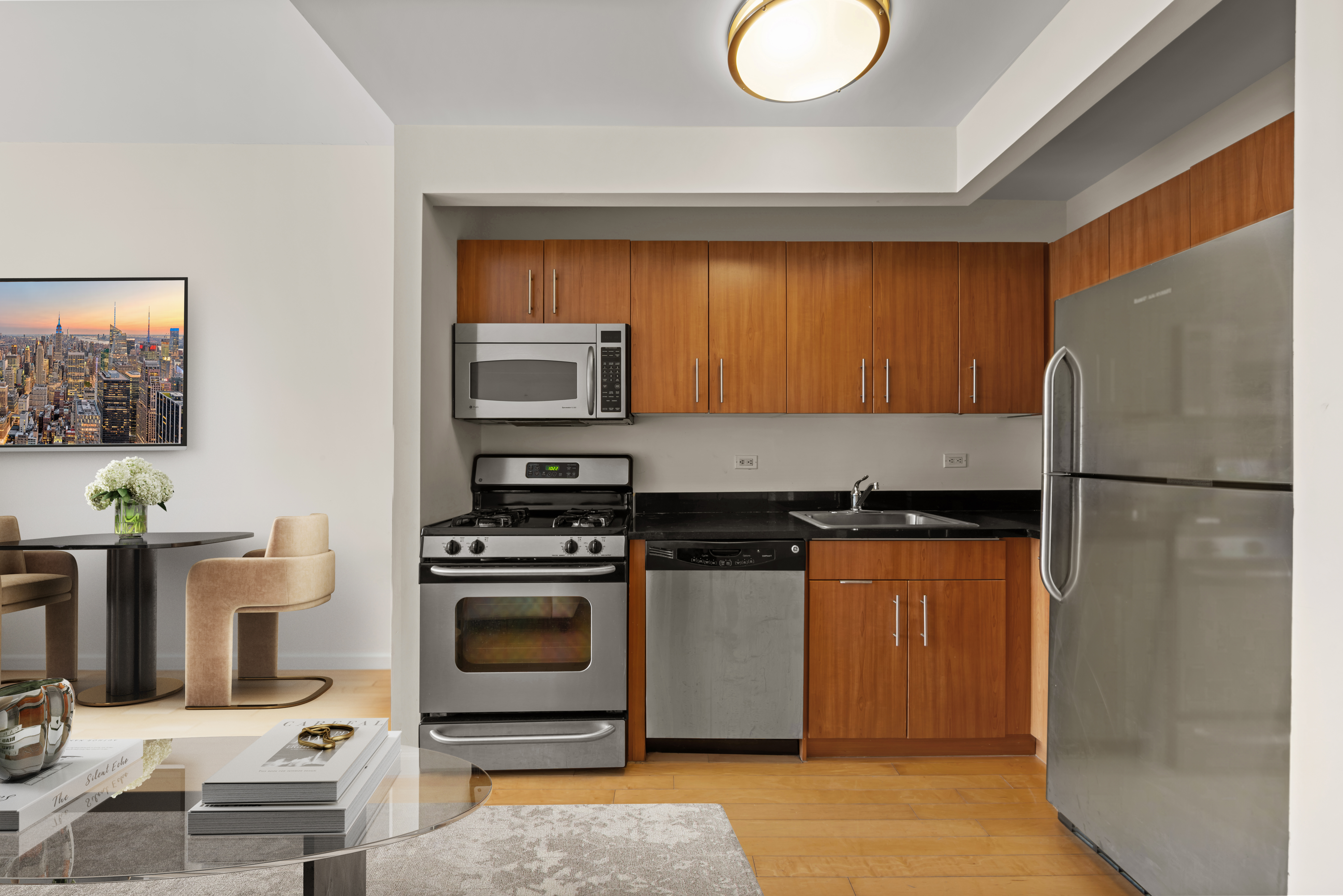 20 West Street, Unit 41D Manhattan, NY 10004 - Photo 5 of 17 a kitchen with stainless steel appliances granite countertop a refrigerator a stove and a sink with wooden floor