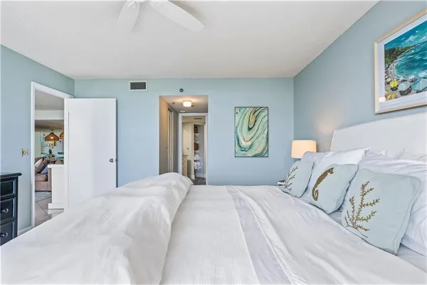 a bedroom with a bed and painting on the wall