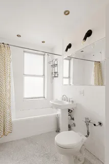 a bathroom with a toilet a sink a mirror and a bathtub