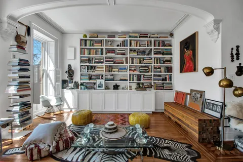 a living room with furniture and a book shelf