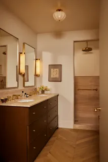 a bathroom with a double vanity sink a mirror and a shower