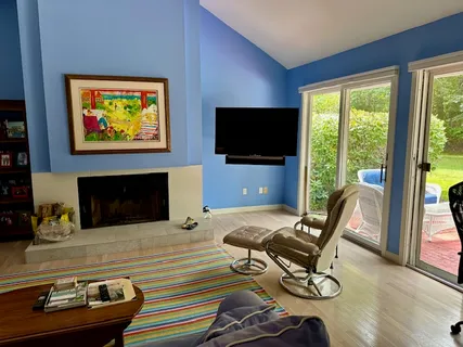 a living room with furniture a flat screen tv and a floor to ceiling window