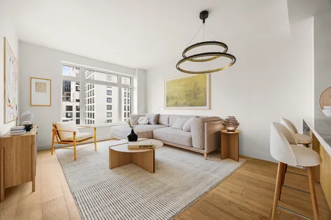 a living room with furniture a rug and a window