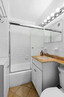 a bathroom with a granite countertop sink mirror vanity and toilet