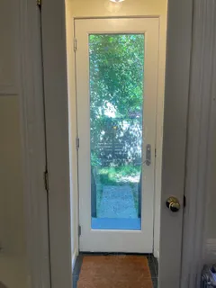 a view of a small space with wooden floor and a window