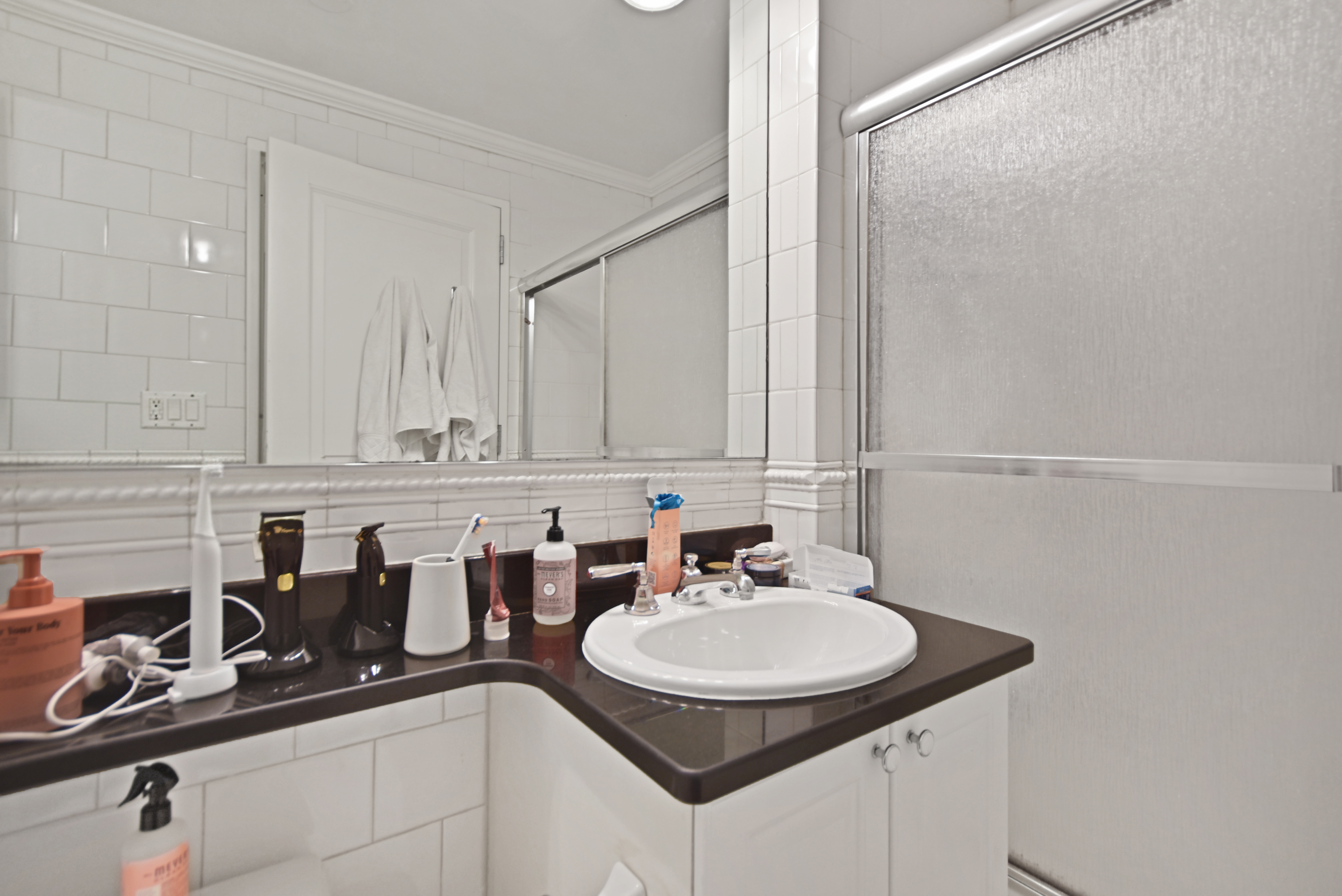 404 East 76th Street, Unit 4A Manhattan, NY 10021 - Photo 5 of 6 a sink with a granite countertop white cabinets and a sink