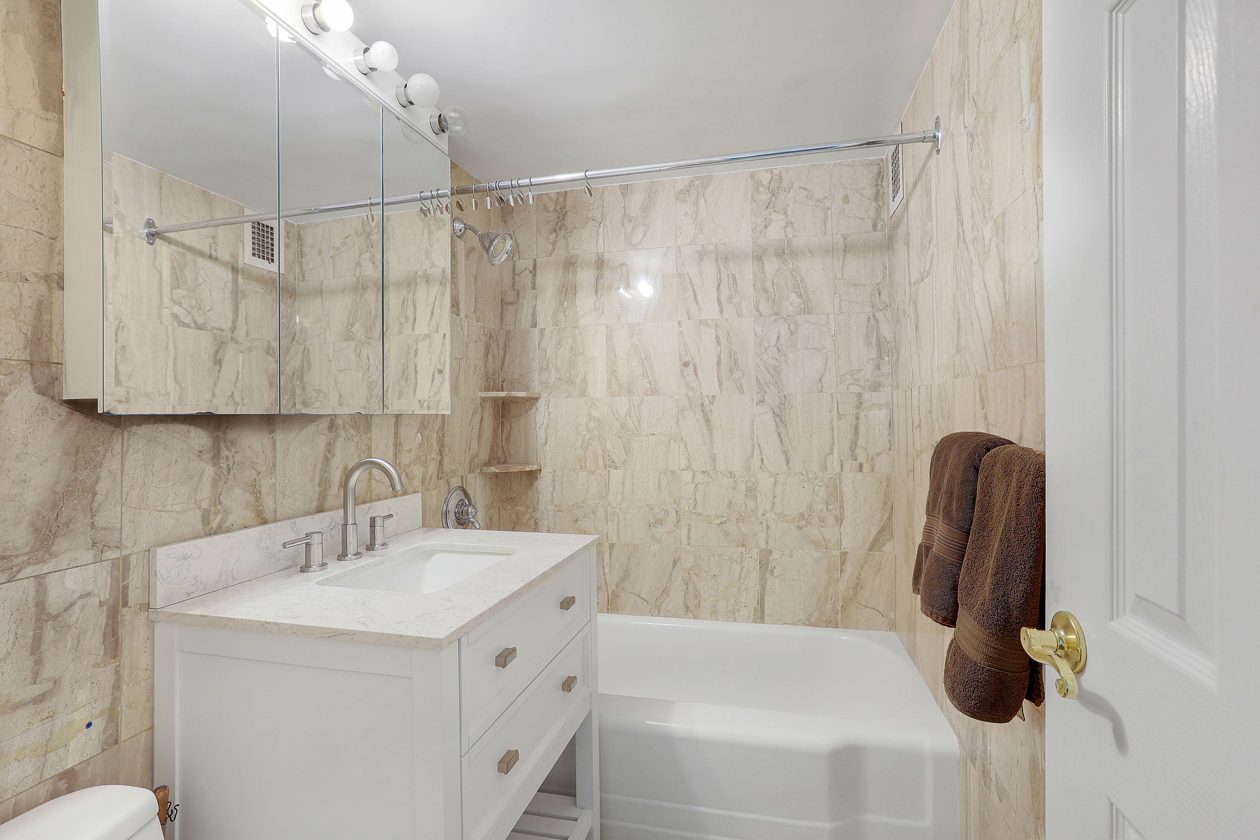 100 West 57th Street, Unit 15N Manhattan, NY 10019 - Photo 7 of 9 a bathroom with a sink a toilet and shower