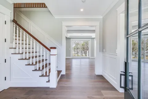 a kitchen with a sink stove and white cabinets with wooden floor