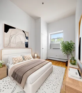 a bedroom with a bed and a potted plant