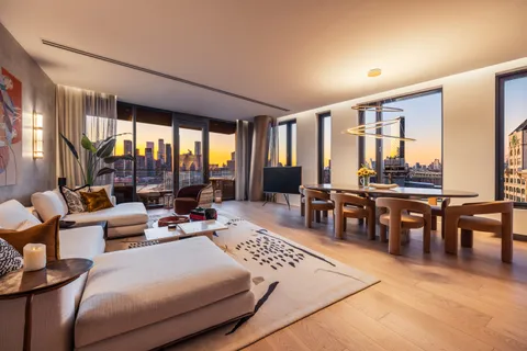 a living room with lots of furniture and floor to ceiling windows