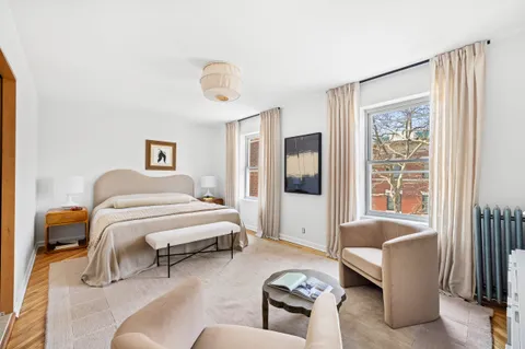a bedroom with furniture and a large window