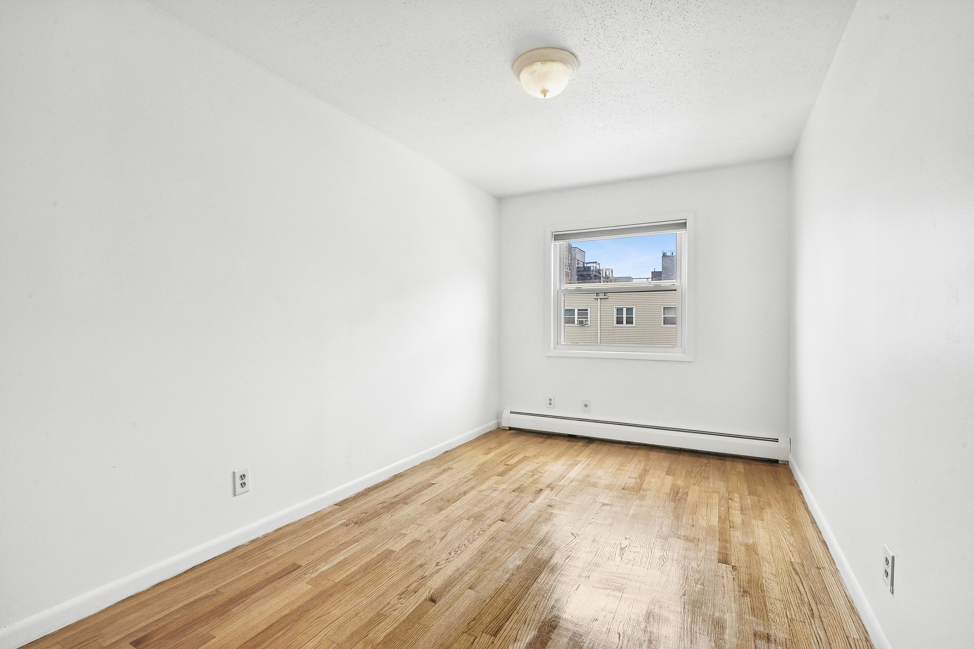 97 Baltic Street, Unit 3 Brooklyn, NY 11201 - Photo 7 of 9 an empty room with wooden floor and windows