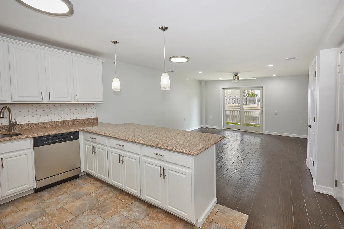 10220 Rockaway Beach Boulevard, Unit 1A Queens, NY 11694 - Photo 2 of 8 a kitchen with granite countertop white cabinets and white appliances
