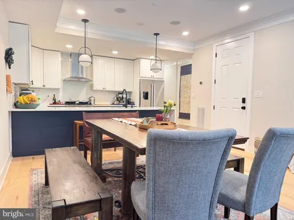 a kitchen with kitchen island a dining table chairs sink and cabinets