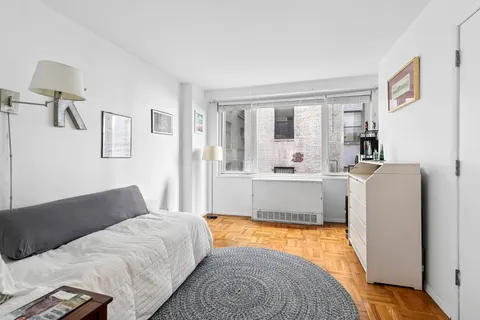 a living room with a bed furniture and next to a window