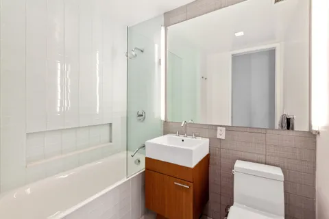a bathroom with a tub sink and mirror