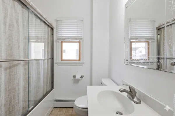 a bathroom with a sink and mirror with toilet