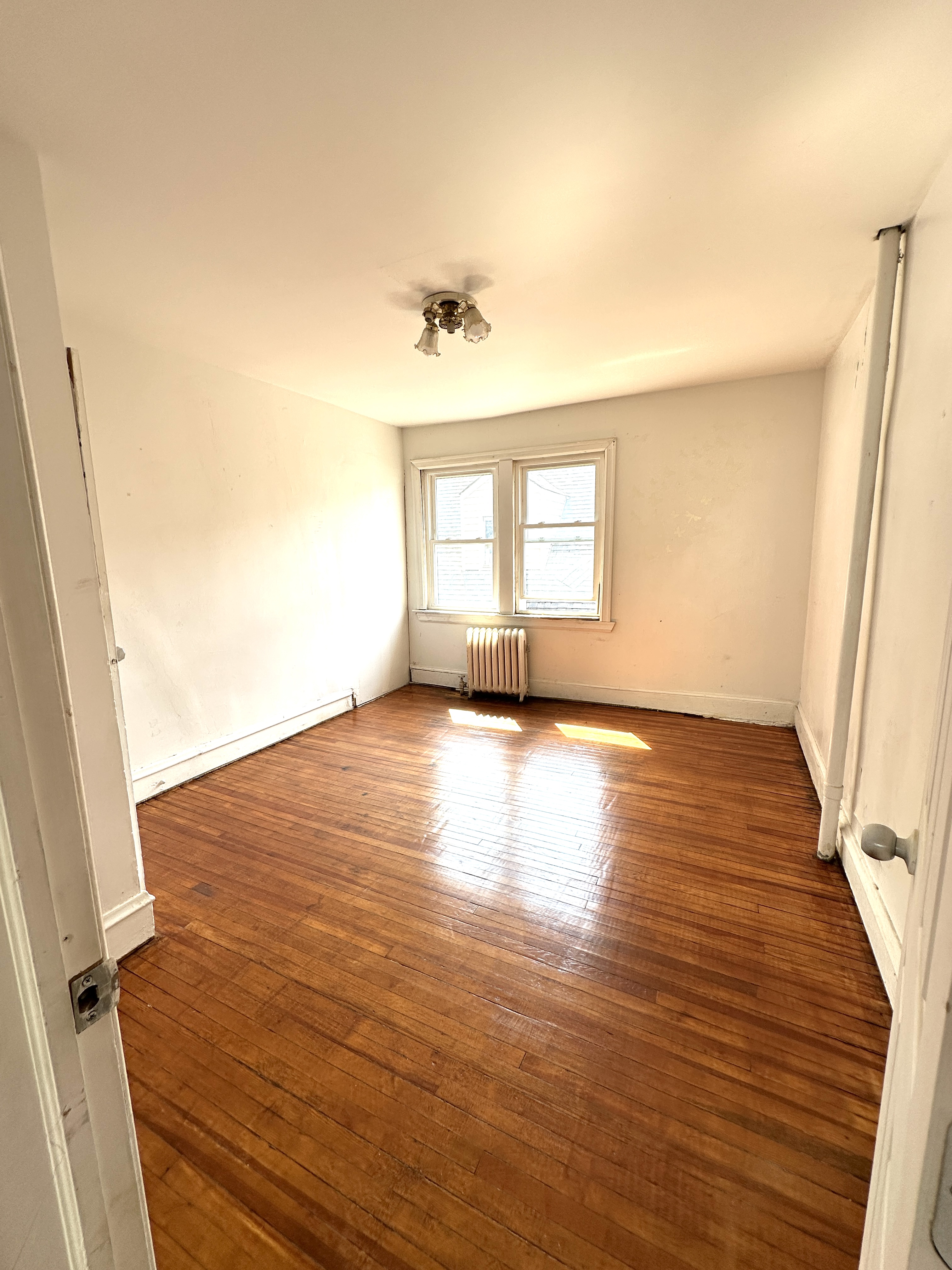 92-64 Springfield Boulevard Queens, NY 11428 - Photo 15 of 25 wooden floor in an empty room with a window