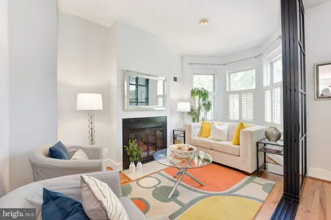 a living room with furniture fireplace and a large window