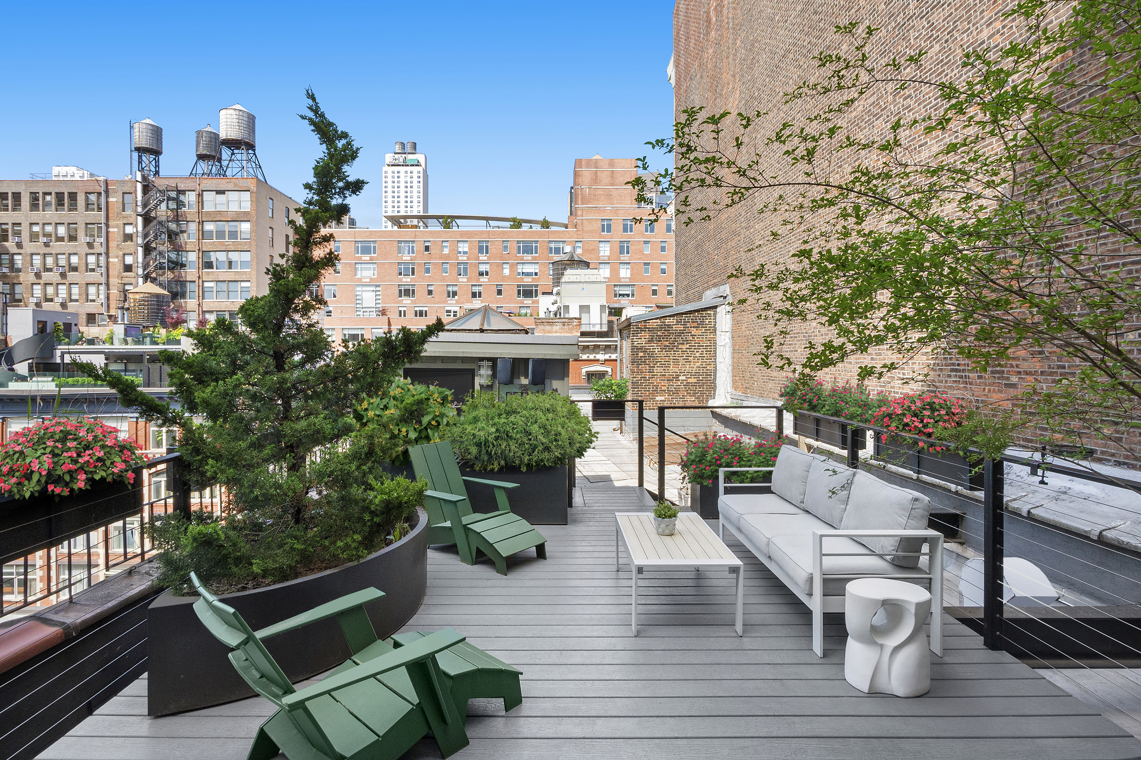 120 West 20th Street, Unit PH Manhattan, NY 10011 - Photo 13 of 15 a roof deck with couches and potted plants with wooden floor and city view