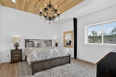 a bedroom with a large bed and a chandelier
