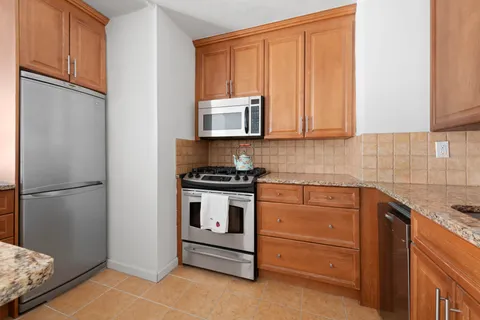 a kitchen with stainless steel appliances granite countertop a refrigerator sink and cabinets