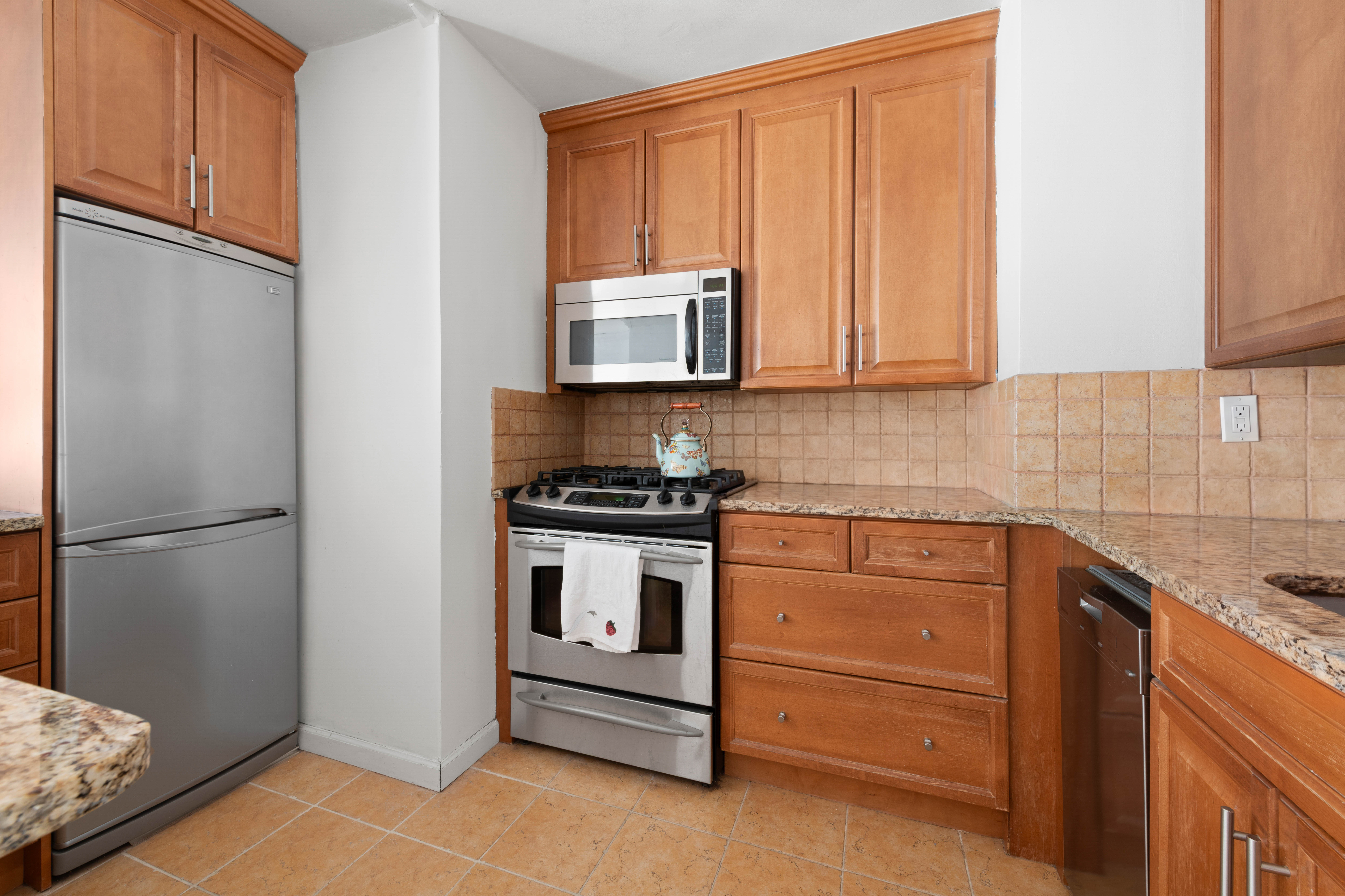 130 East 18th Street, Unit 10M Manhattan, NY 10003 - Photo 6 of 8 a kitchen with stainless steel appliances granite countertop a refrigerator sink and cabinets
