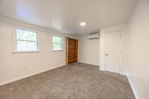 an empty room with windows and closet