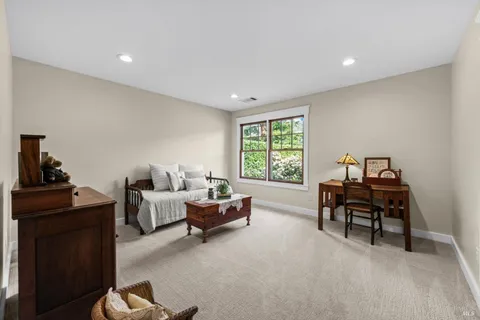 a front view of a house with a garden and trees