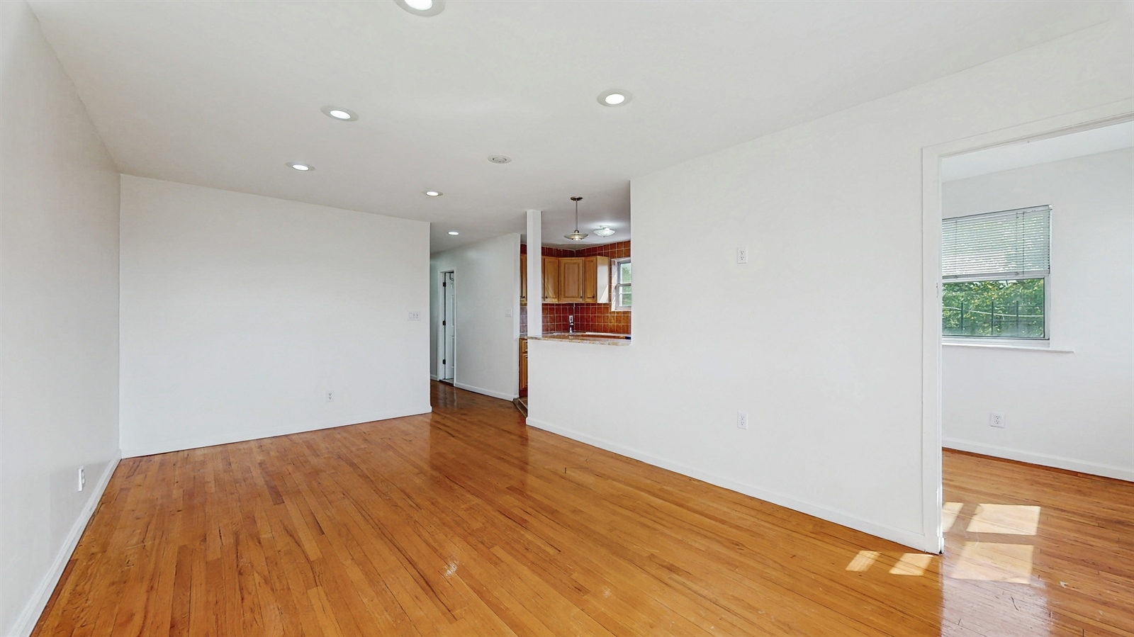 295 Conklin Avenue, Unit 3 Brooklyn, NY 11236 - Photo 5 of 15 wooden floor in an empty room with a window
