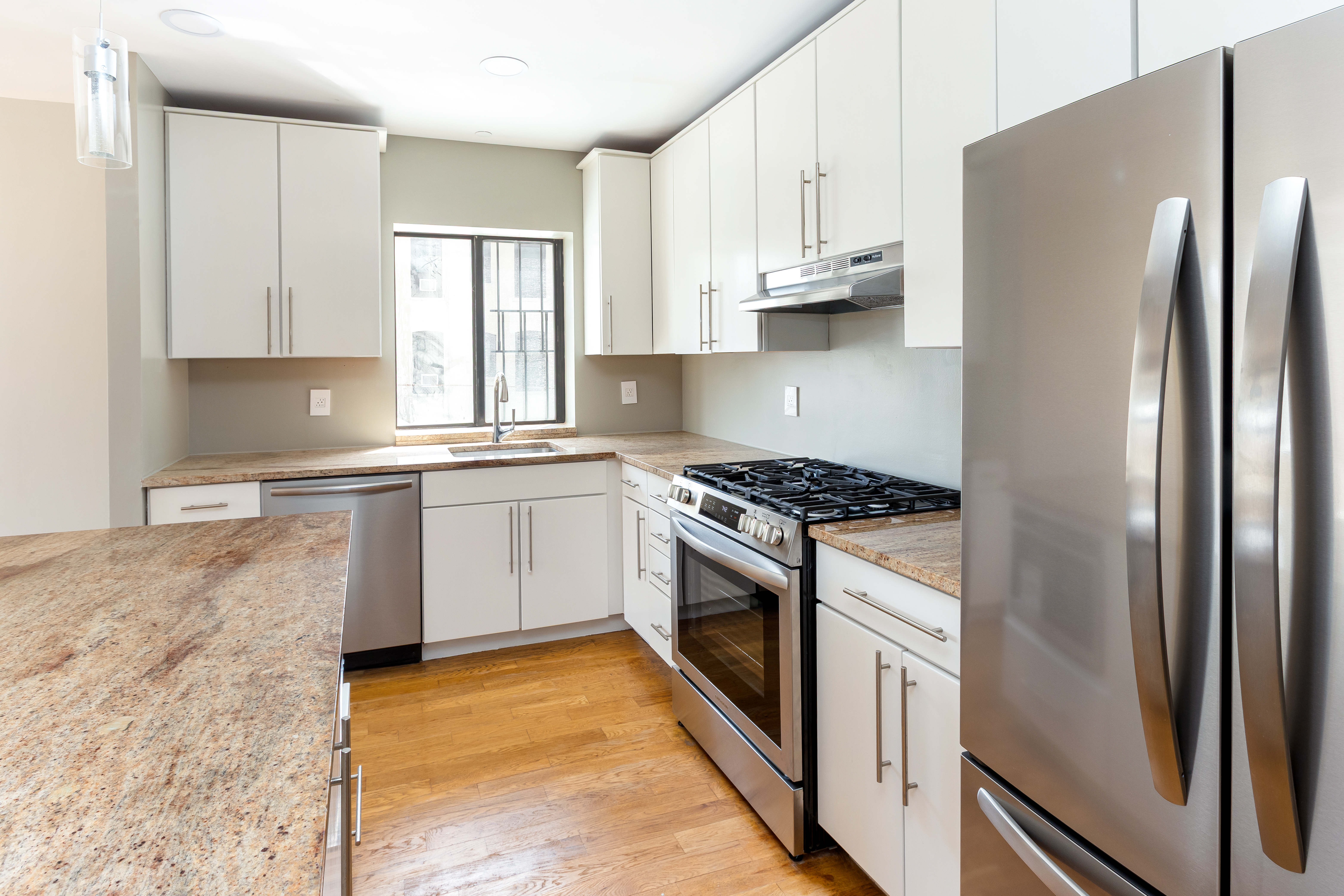 416 East 117th Street, Unit 5A Manhattan, NY 10035 - Photo 3 of 16 a kitchen with granite countertop a refrigerator stove and sink