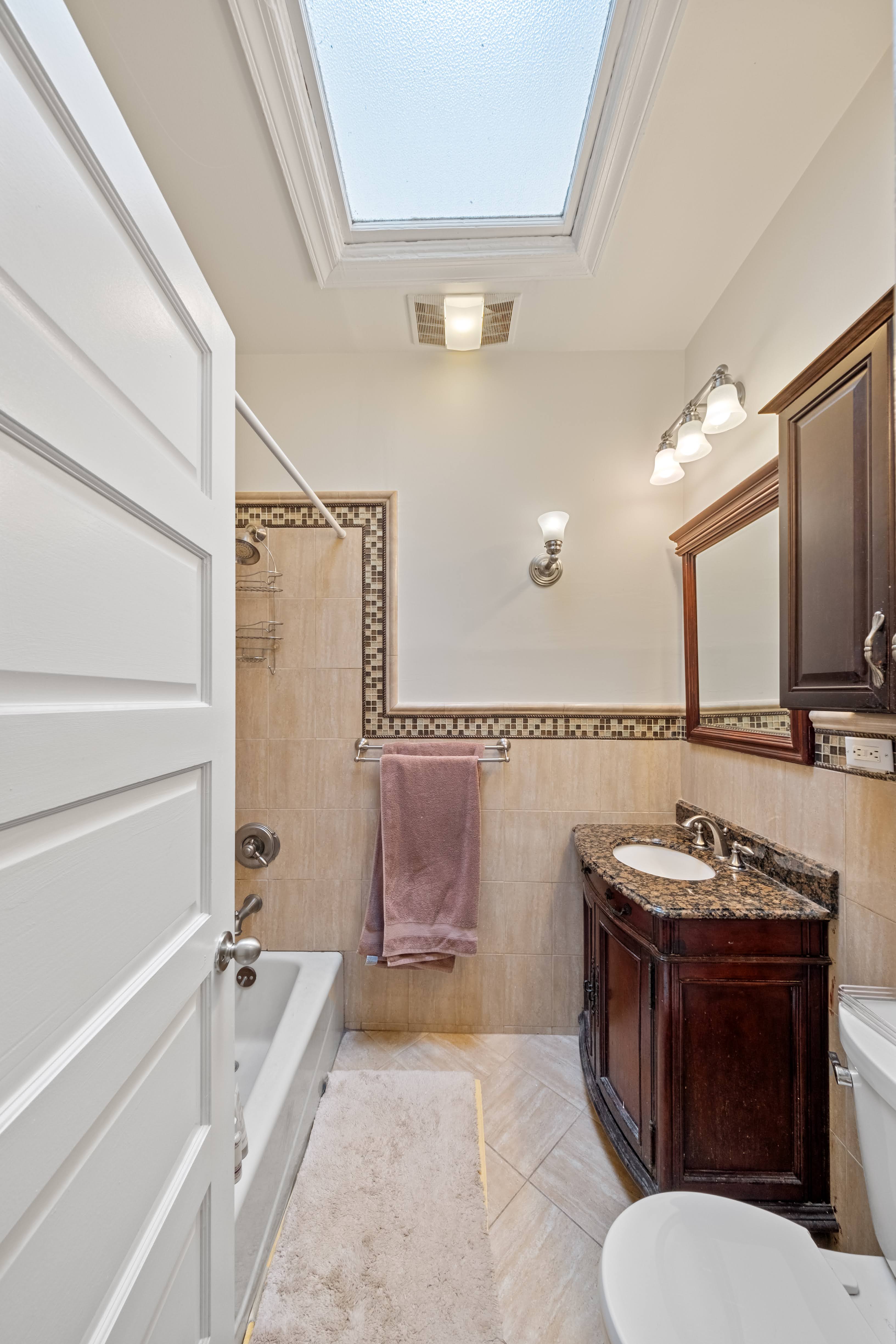 196 Maple Street Brooklyn, NY 11225 - Photo 19 of 31 a bathroom with a granite countertop sink mirror vanity and bathtub