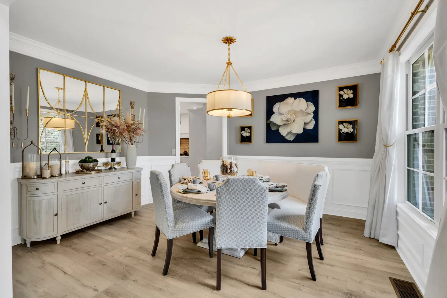 a dining room with wooden floor a chandelier a wooden table and chairs