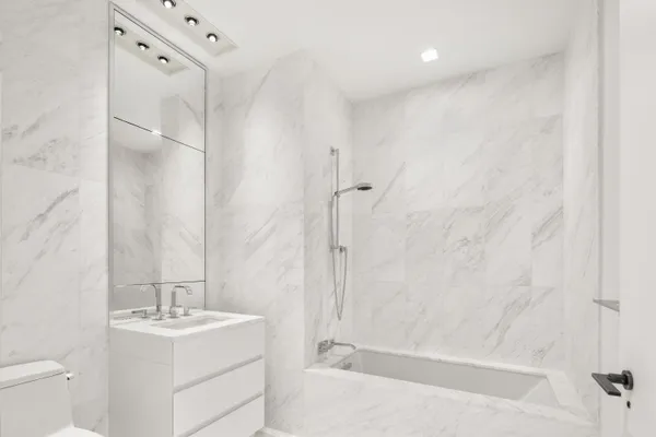 a bathroom with a granite countertop sink a toilet and shower