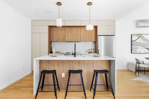 a kitchen with kitchen island a dining table chairs sink and cabinets